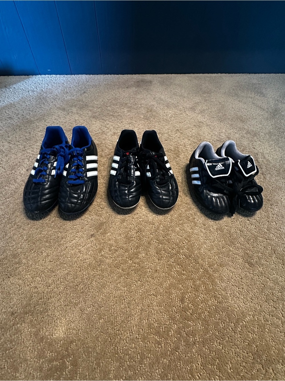 adidas Kids Black Soccer Shoes with White Stripes and Blue Accents